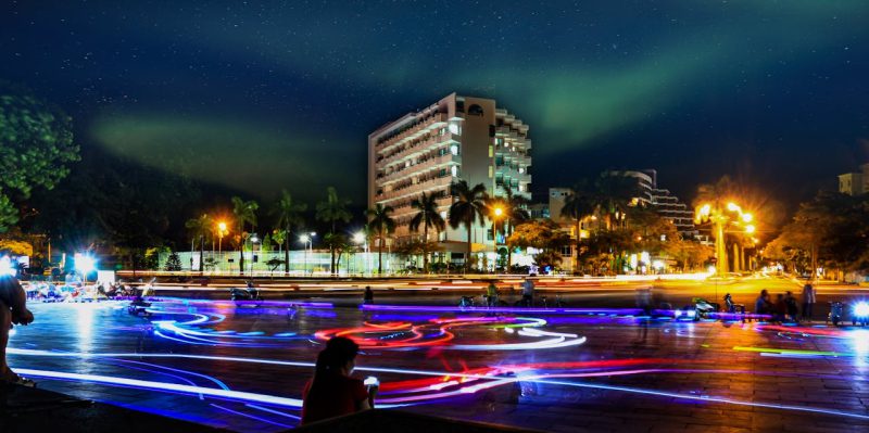 night shot in vietnam with bright neon lights and a hotel building