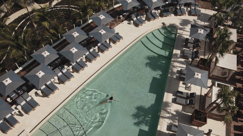 Lady swimming in the large swimming pool at one of the best branded residences in Fort Lauderdale Four Seasons Residences